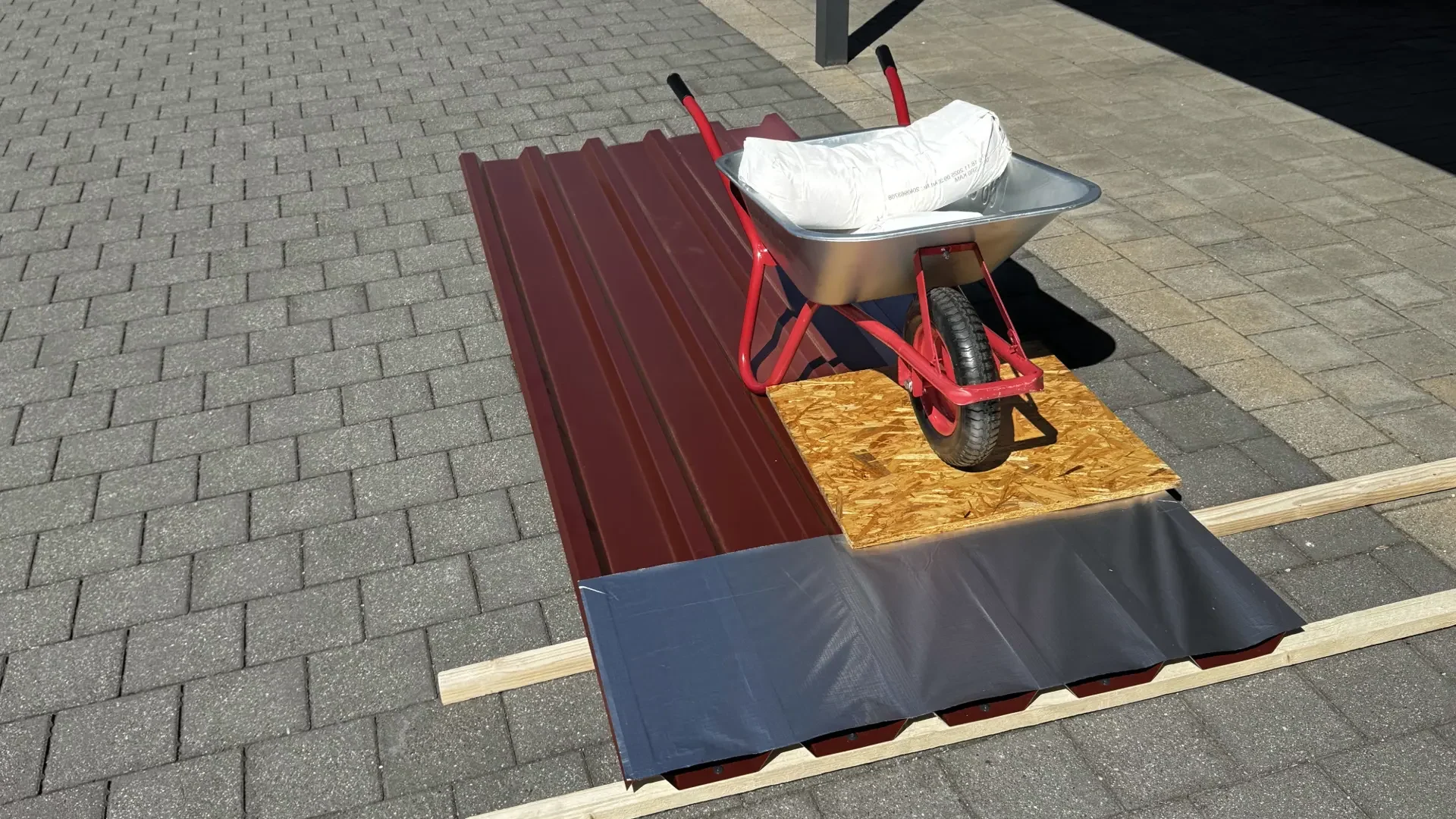 Beladene Schubkarre als rollende Punktlast über selbstklebende BTF Dampfsperre auf Trapezblech
